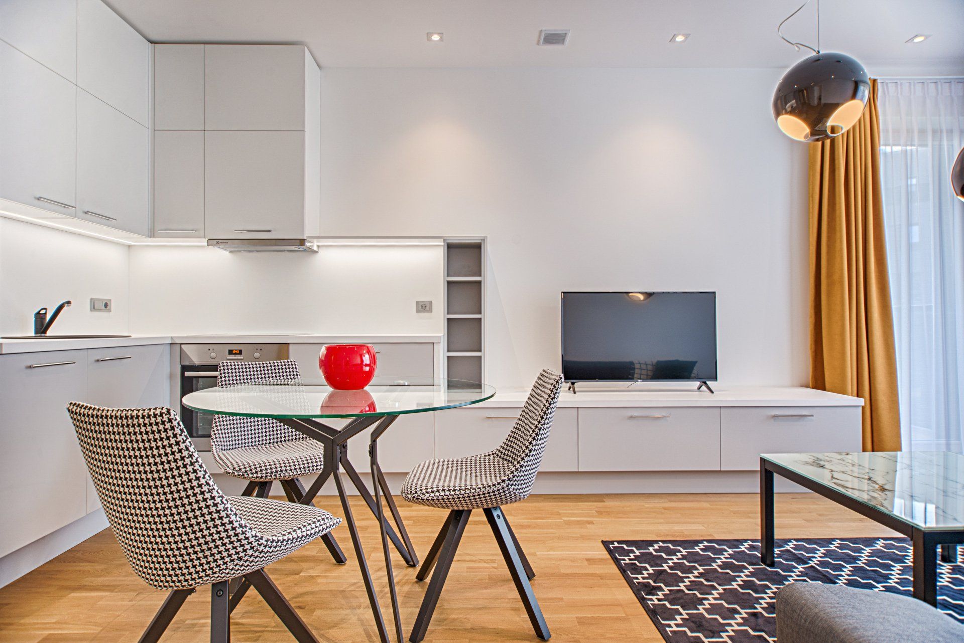 A living room with a table , chairs , and a television.