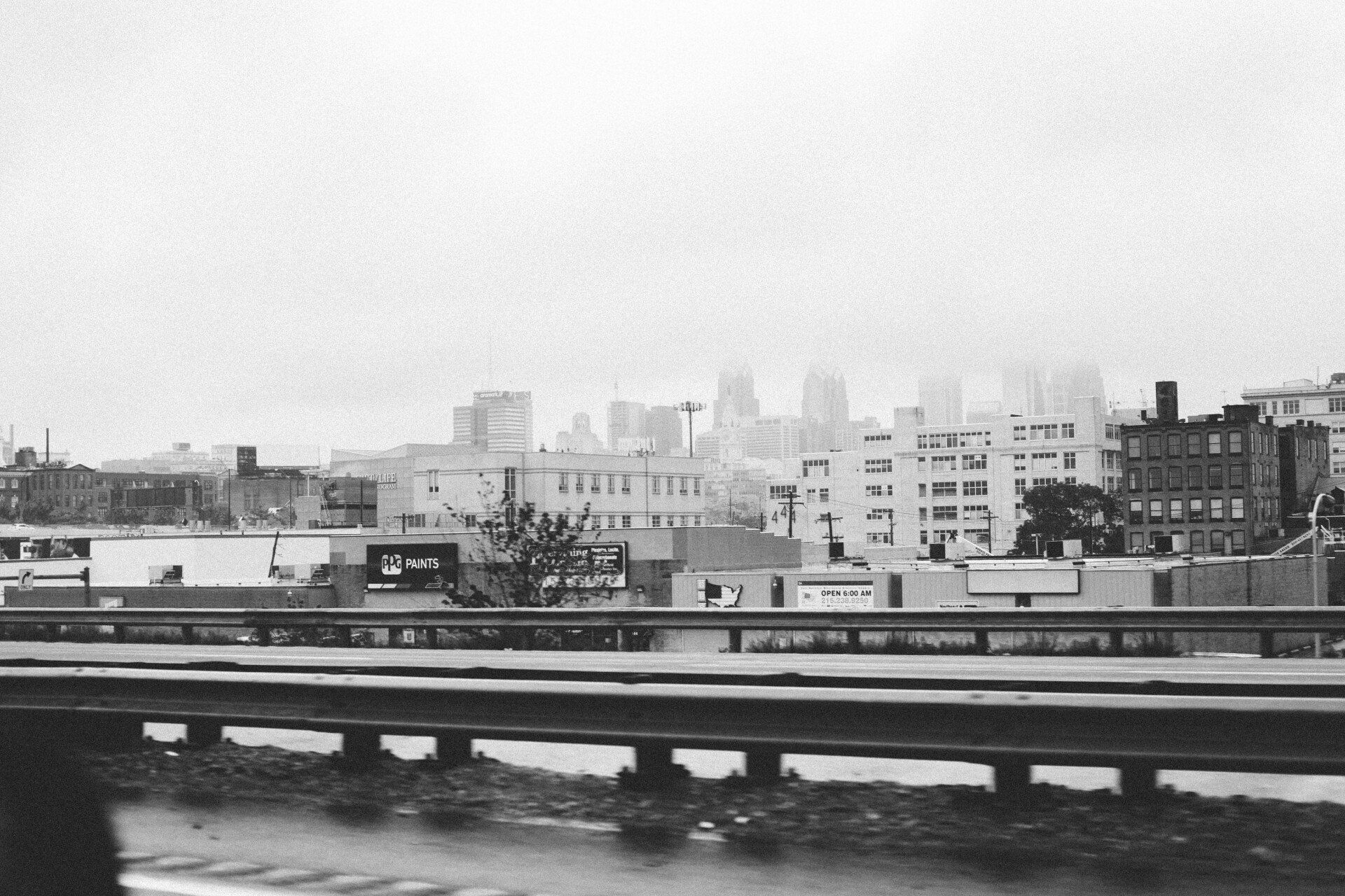 A black and white photo of a city skyline from a highway.