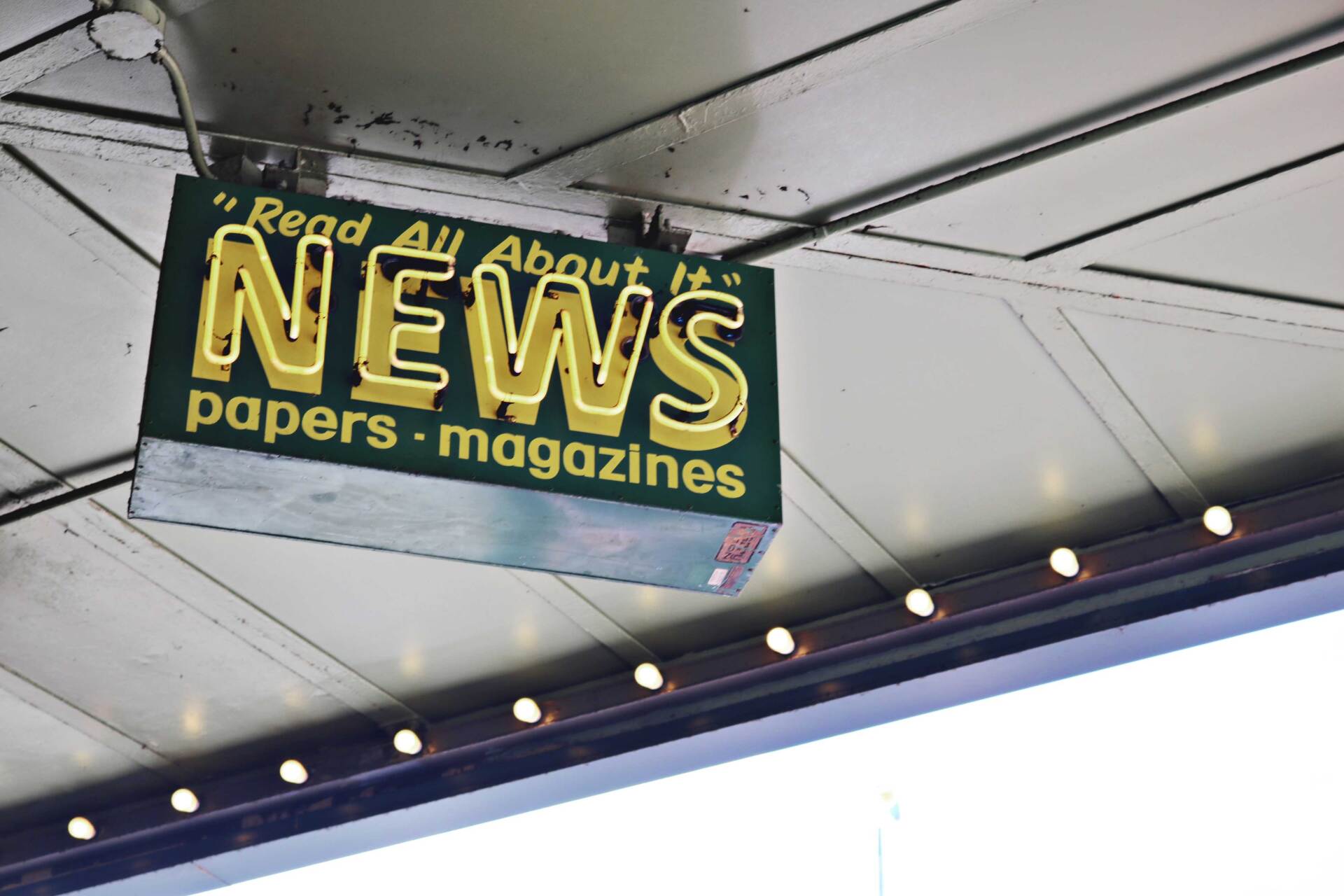 a news sign hangs from the ceiling of a building