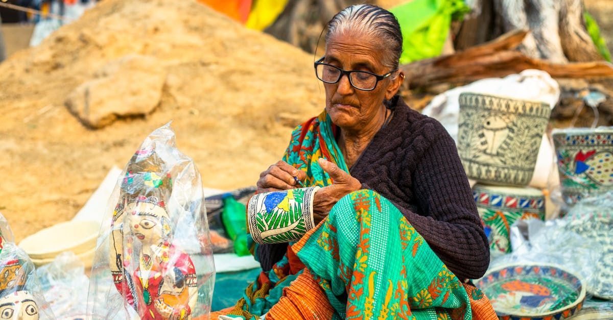 An elderly woman is sitting on the ground selling ceramics.