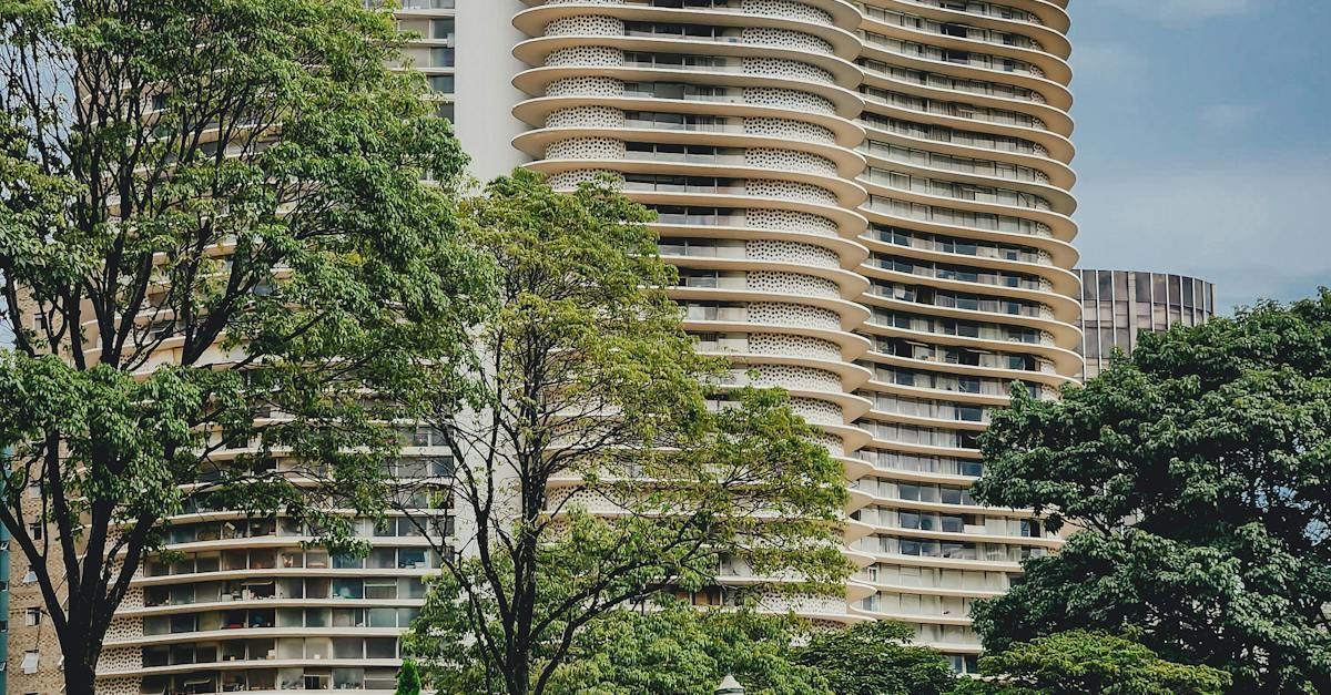 Um prédio alto com muitas janelas cercado por árvores.