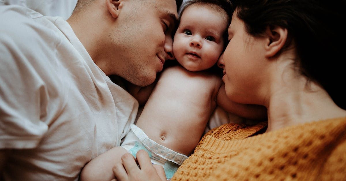 A man and a woman are holding a baby in their arms.