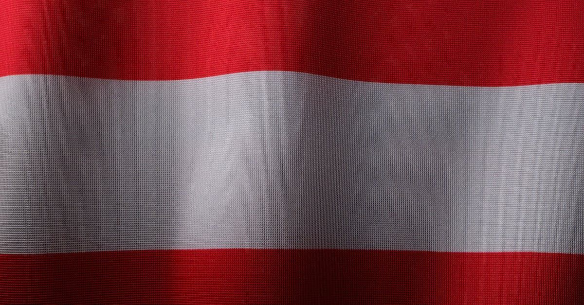 A close up of a red and white flag waving in the wind.