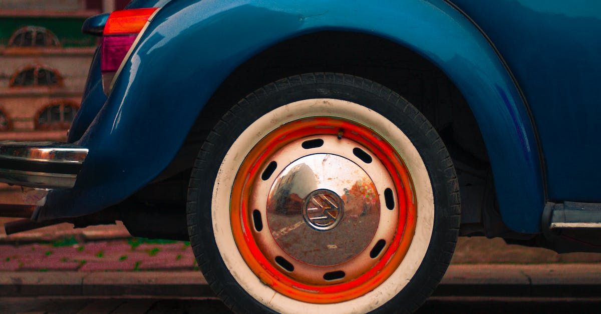 A close up of a blue car with a white tire and red rim.