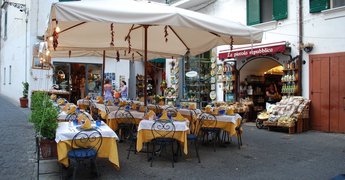 a restaurant with tables and chairs under an umbrella