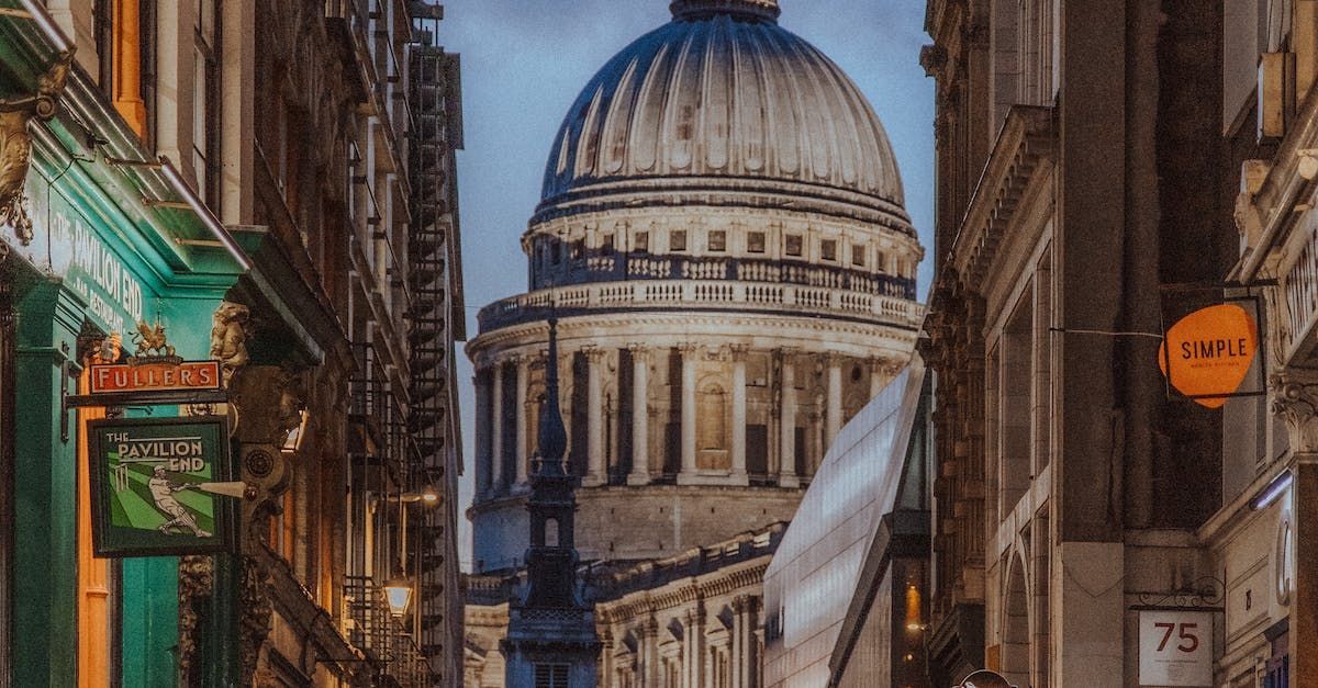 A city street with a dome shaped building in the background.