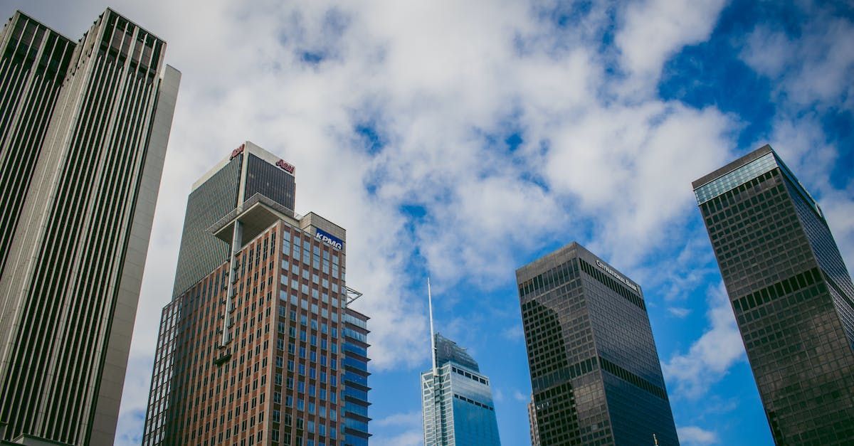 a group of tall buildings against a blue sky with clouds .