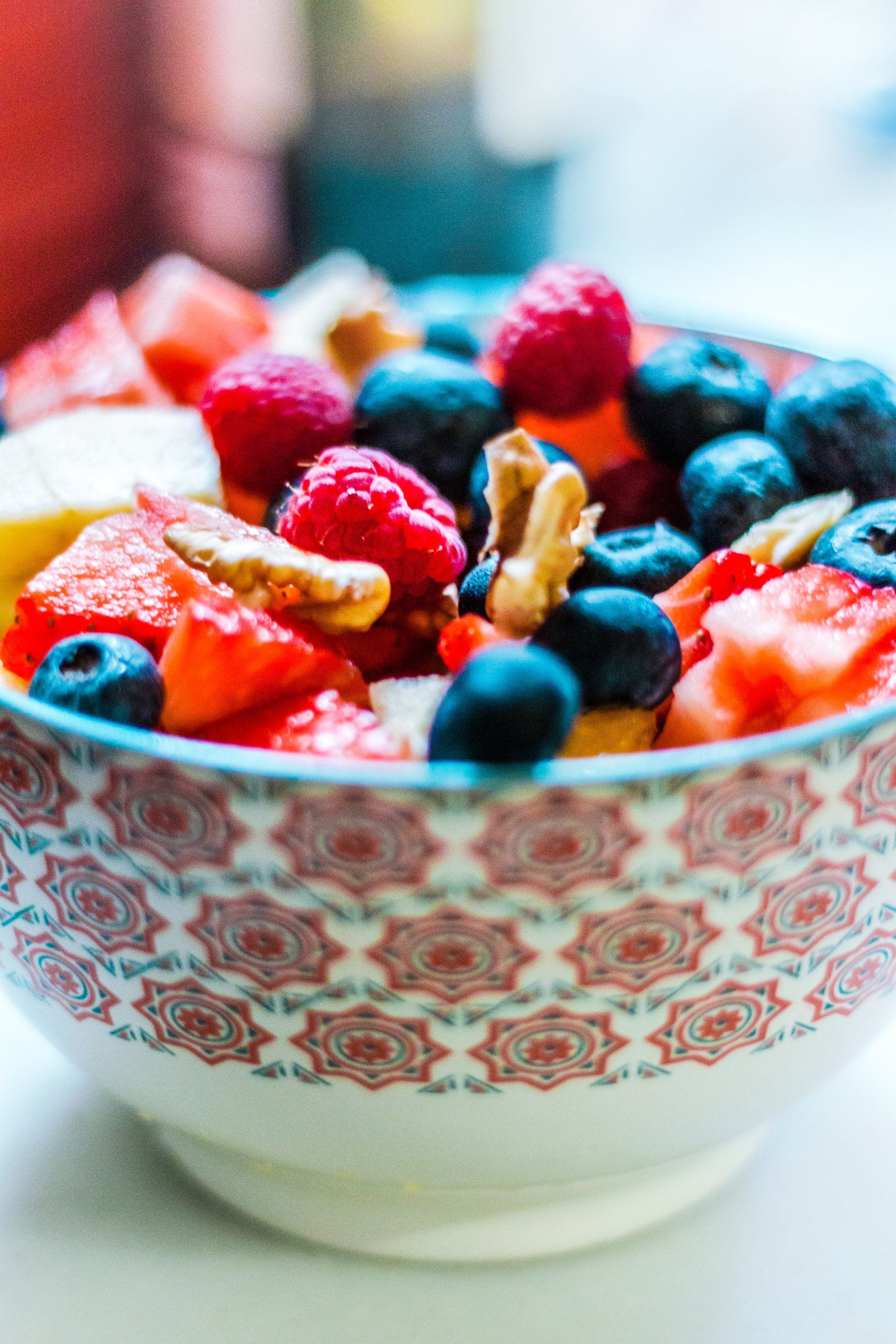 A bowl filled with fruit and nuts on a table.