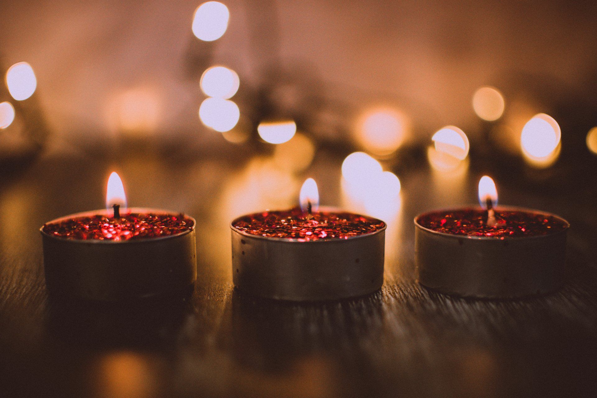 three lit candles are lined up on a table