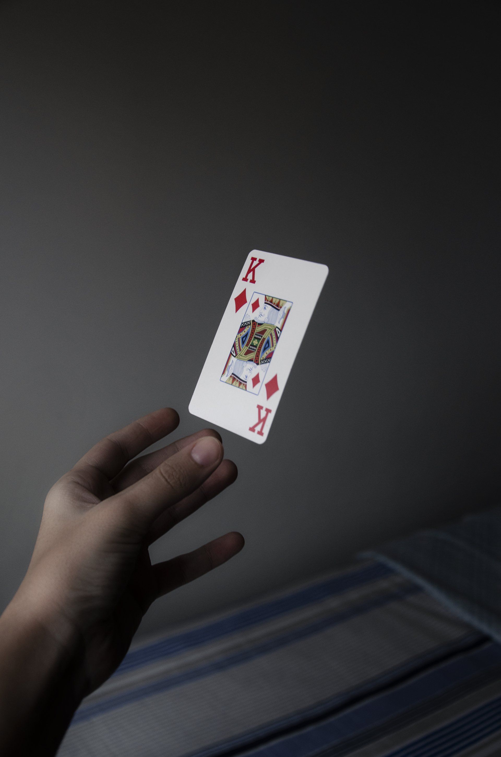 Close up a persons hand throwing the King of Diamonds playing card
