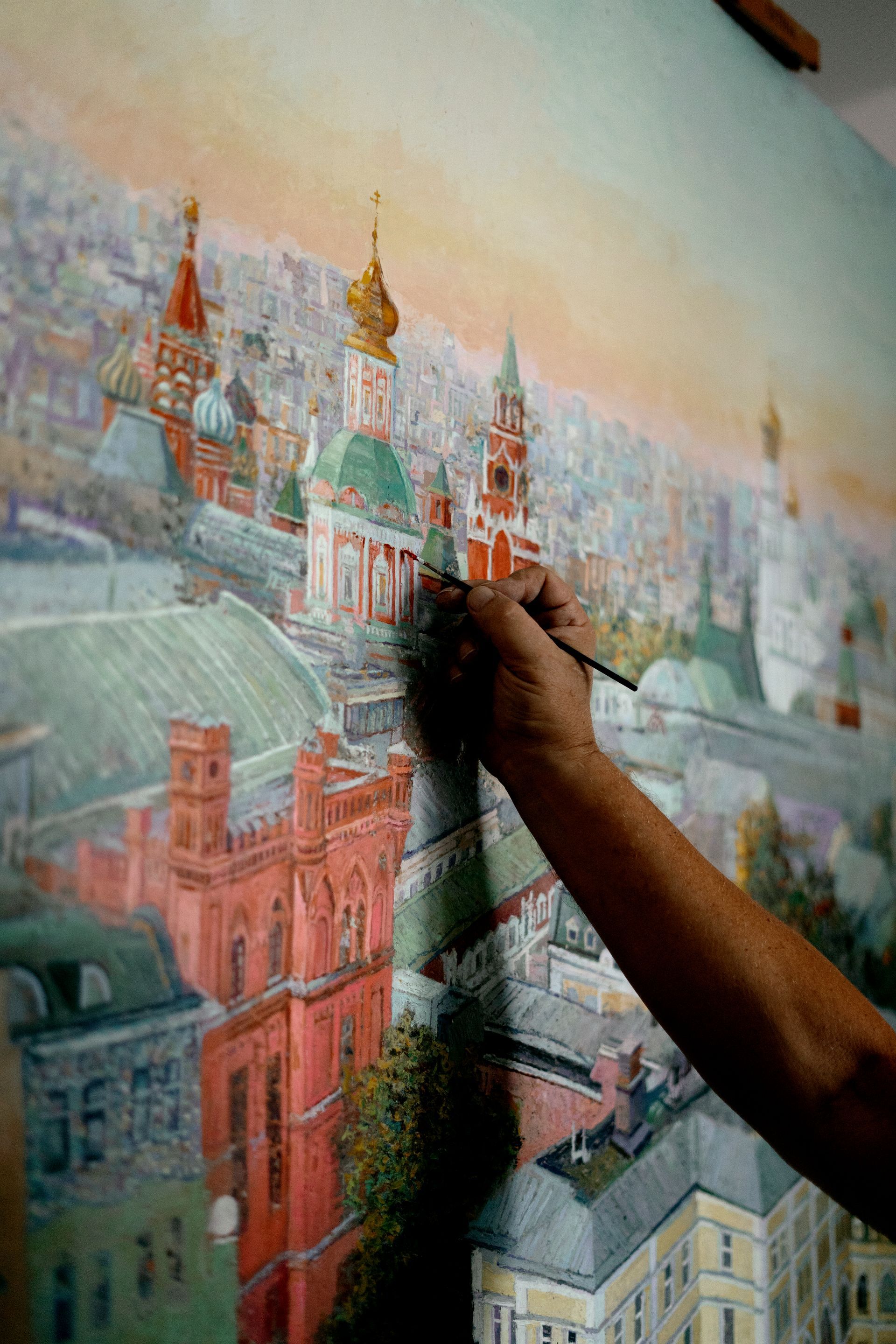 une personne peignant une peinture d' une ville avec un pinceau