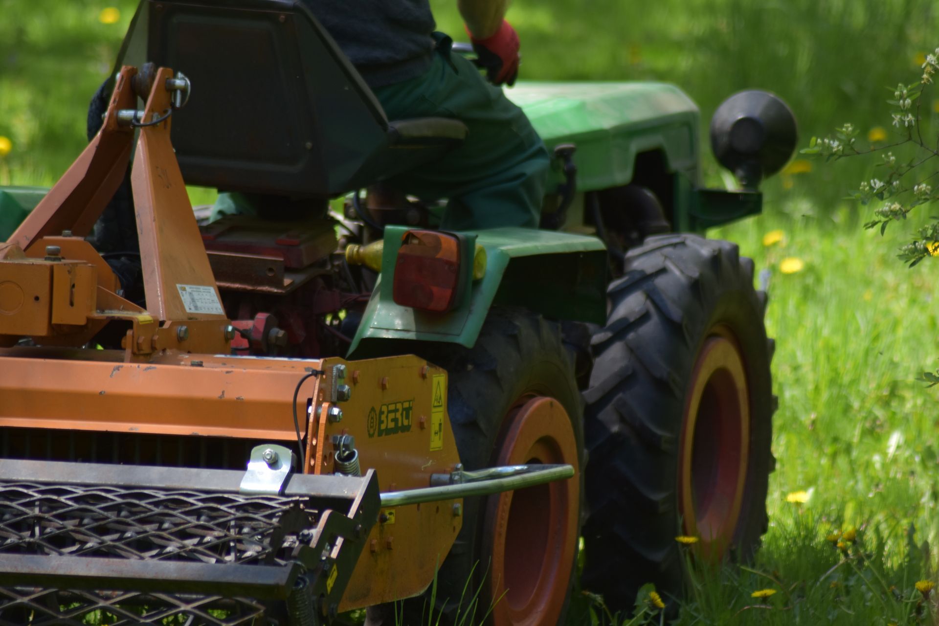 tractor mows dry grass to reduce fire risk