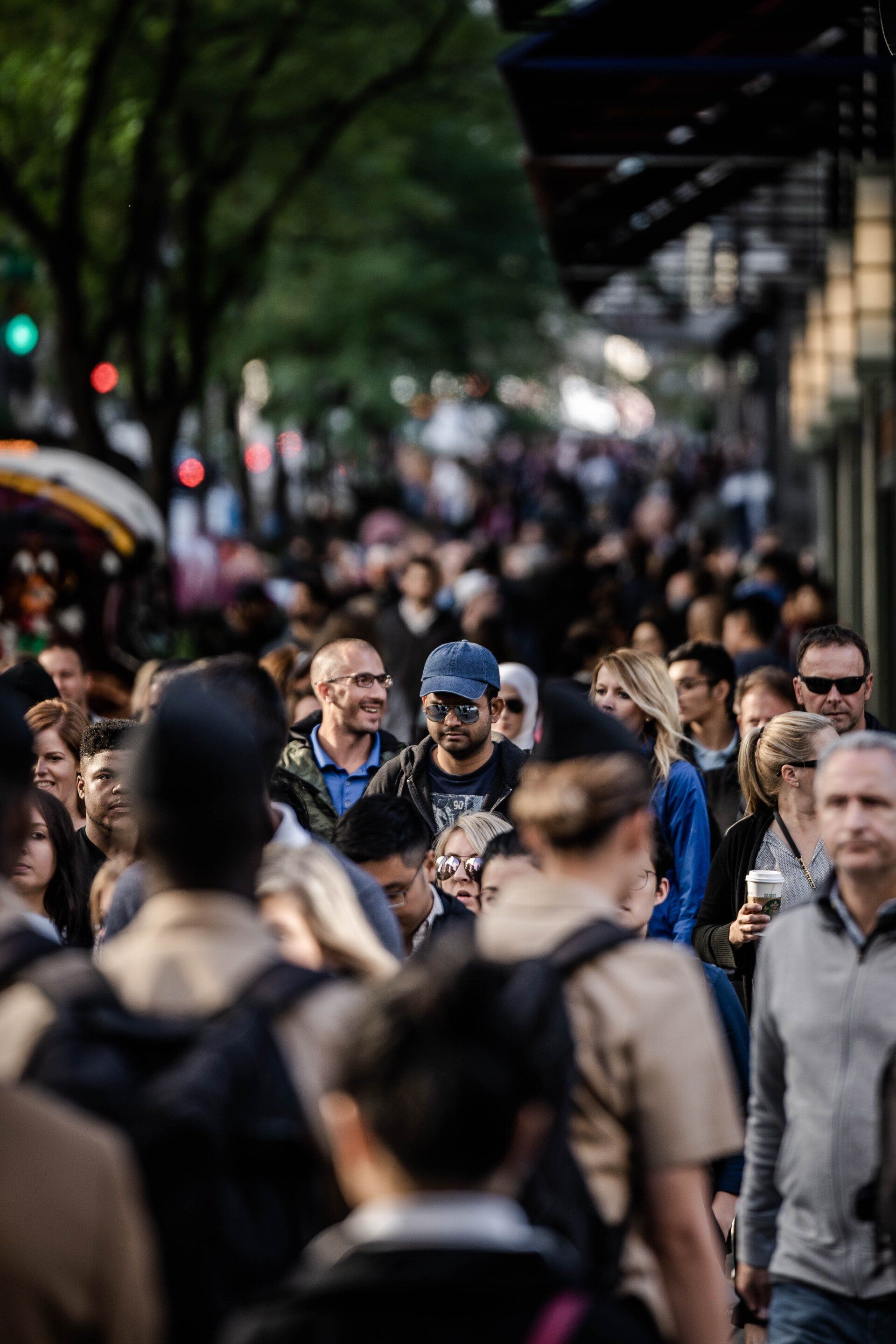 A crowd of people are walking down a city street.