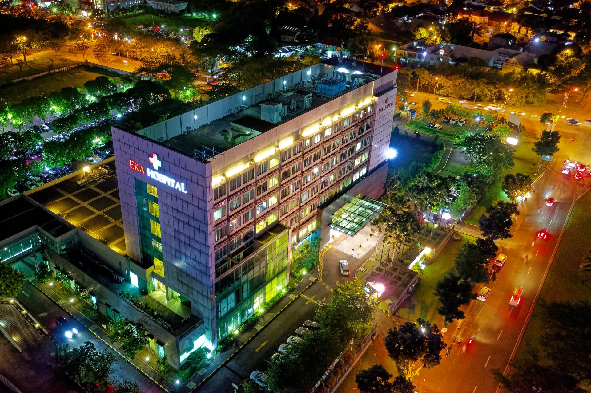 an inner city hospital at night illuminated by lights and street light