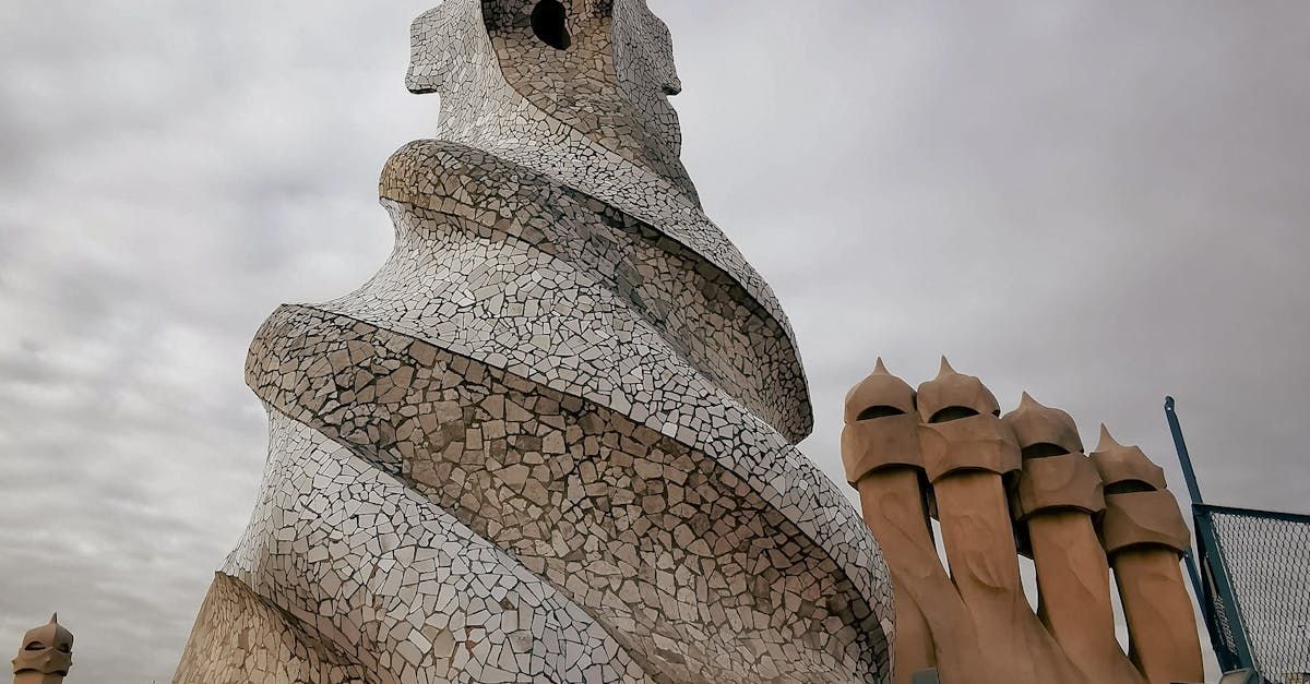A statue of a snake is standing next to a row of chimneys.