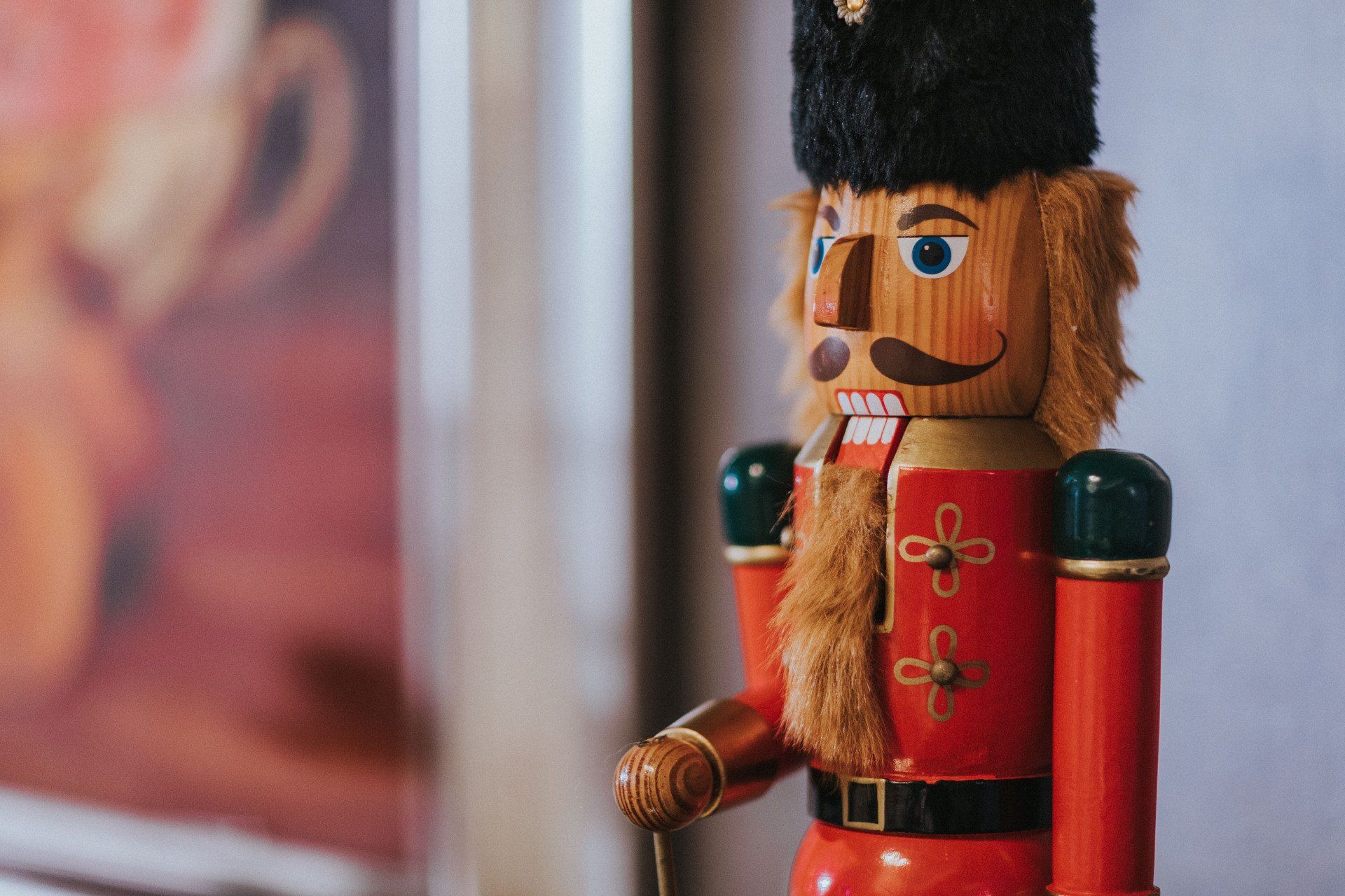 a red nutcracker with a black hat and mustache