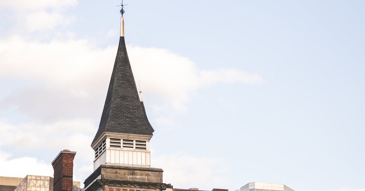 A tall tower with a weather vane on top of it