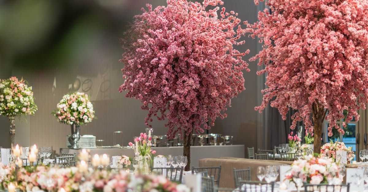 a table decorated with pink flowers and pink cherry blossom trees .