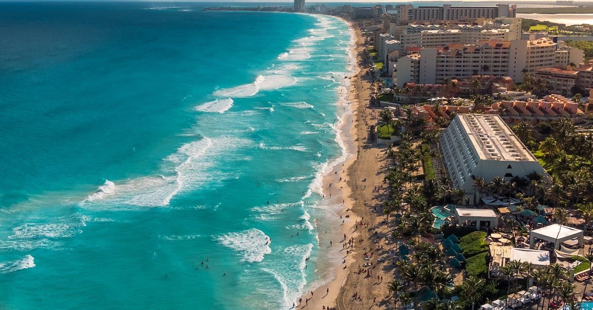 An aerial view of a tropical resort with a swimming pool and palm trees.