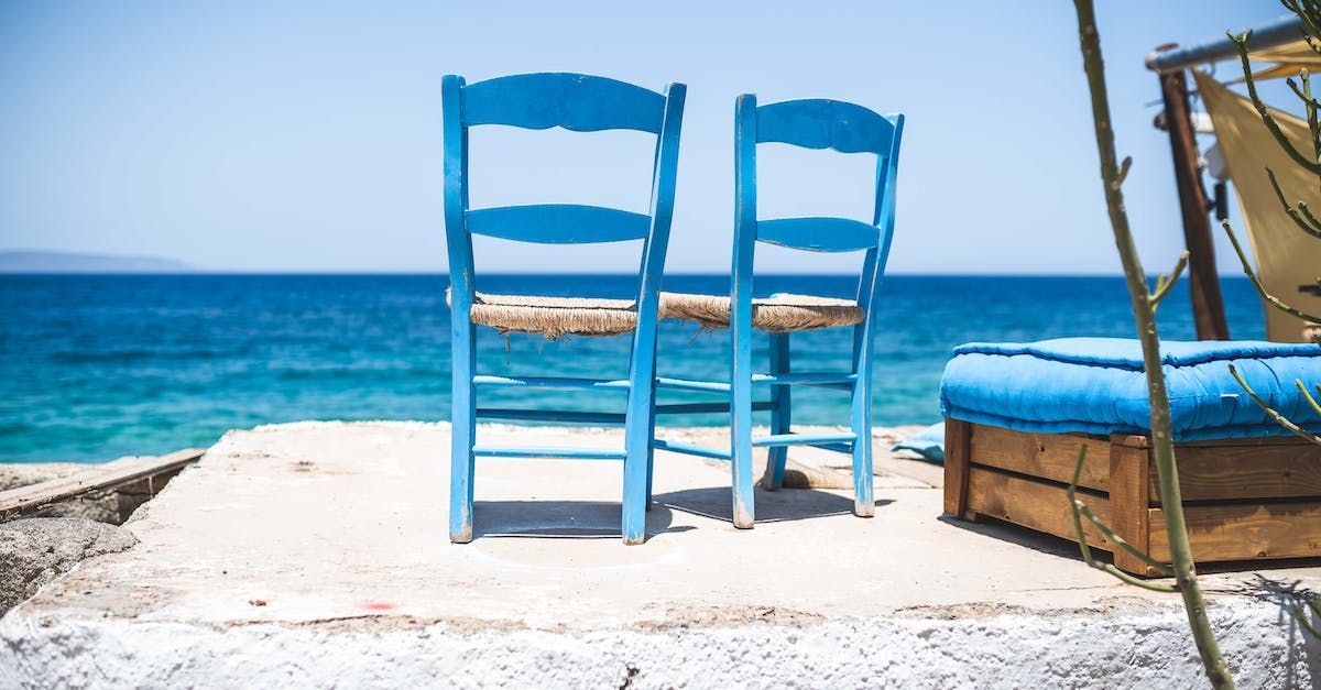 blåmålade trästolar mot blått hav