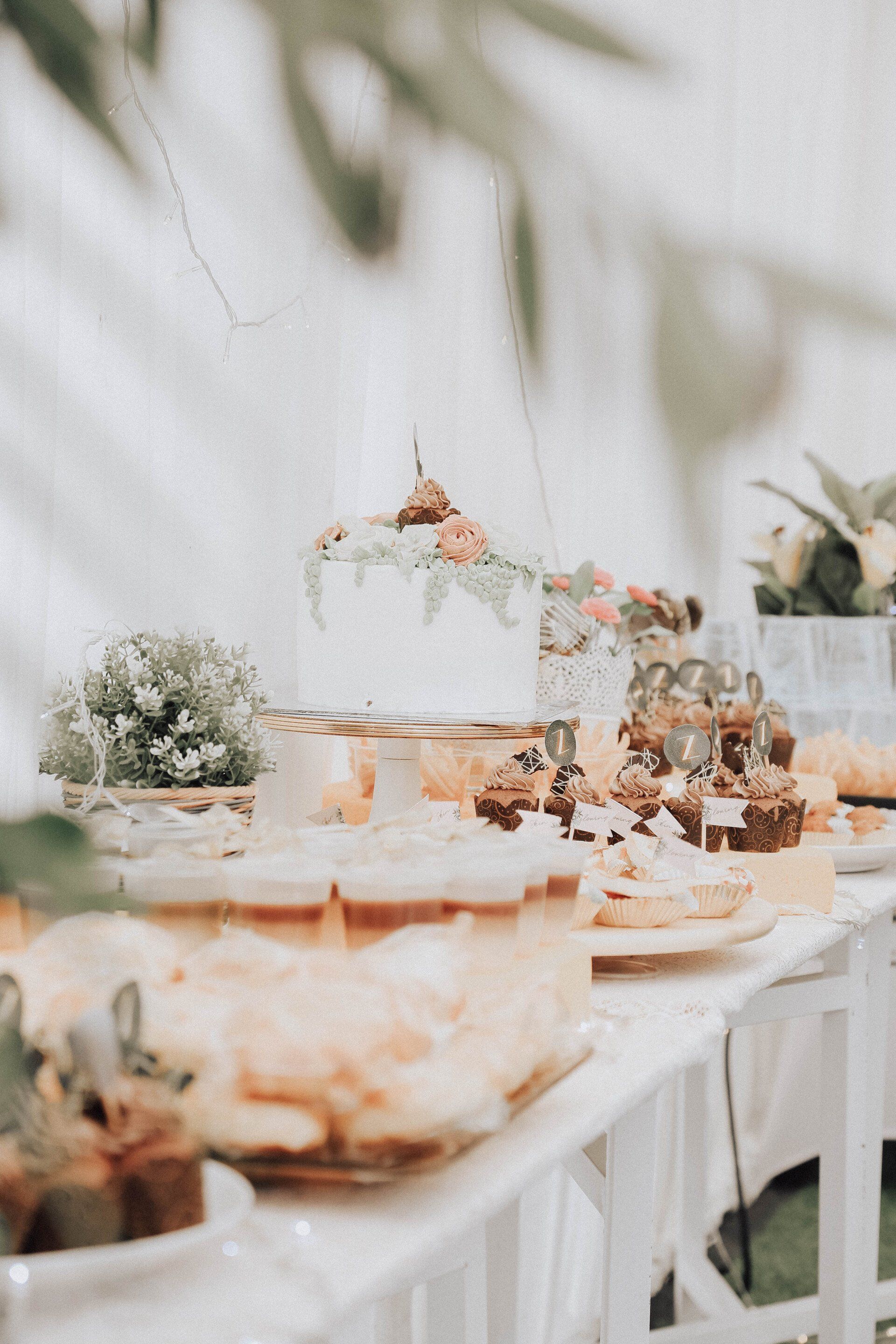 A table topped with a variety of desserts and flowers.