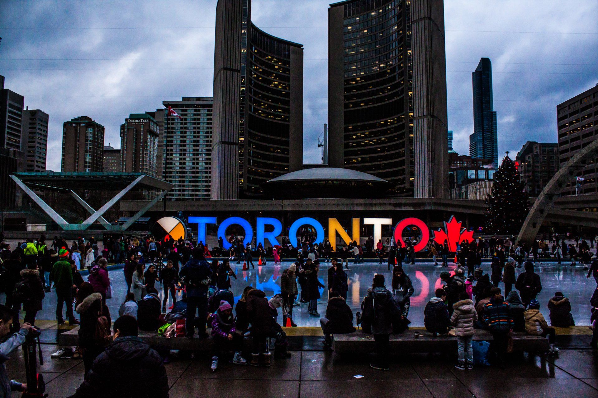A crowd of people are gathered in front of a sign that says toronto.