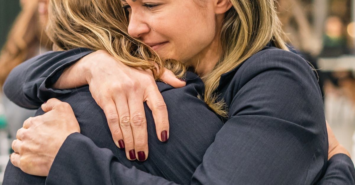 two women are hugging each other and one of them is crying .