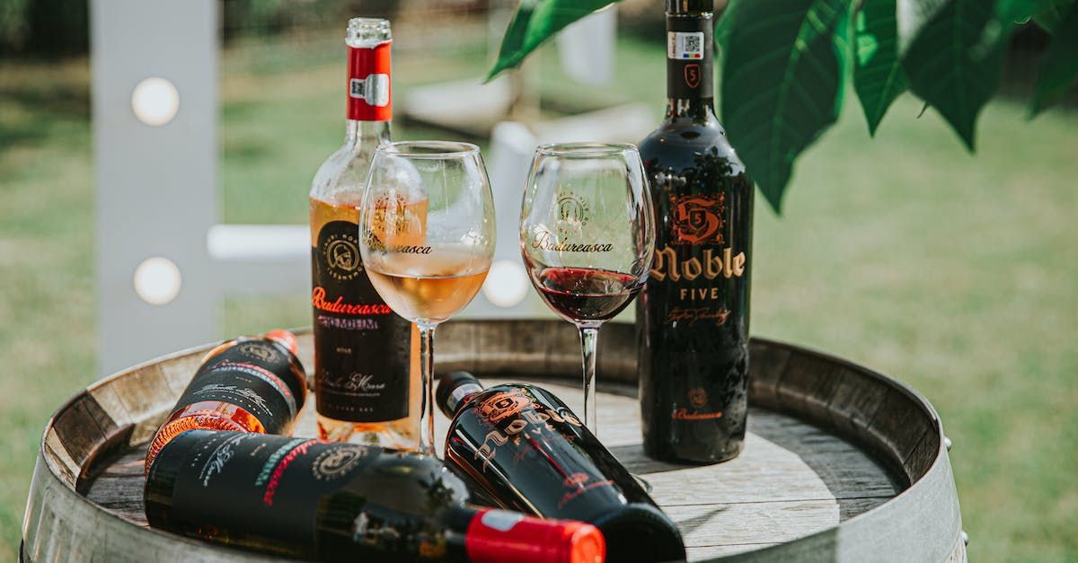 A wooden barrel filled with bottles of wine and wine glasses.