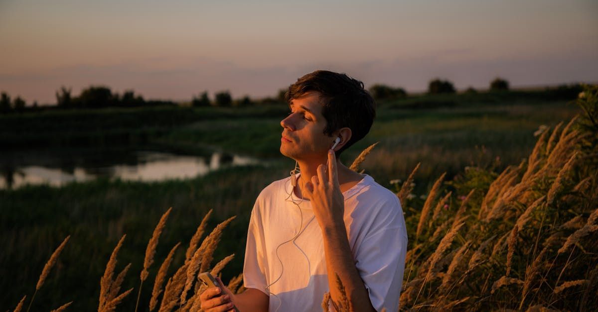een jonge man met een hoofdtelefoon op staat in een graanveld