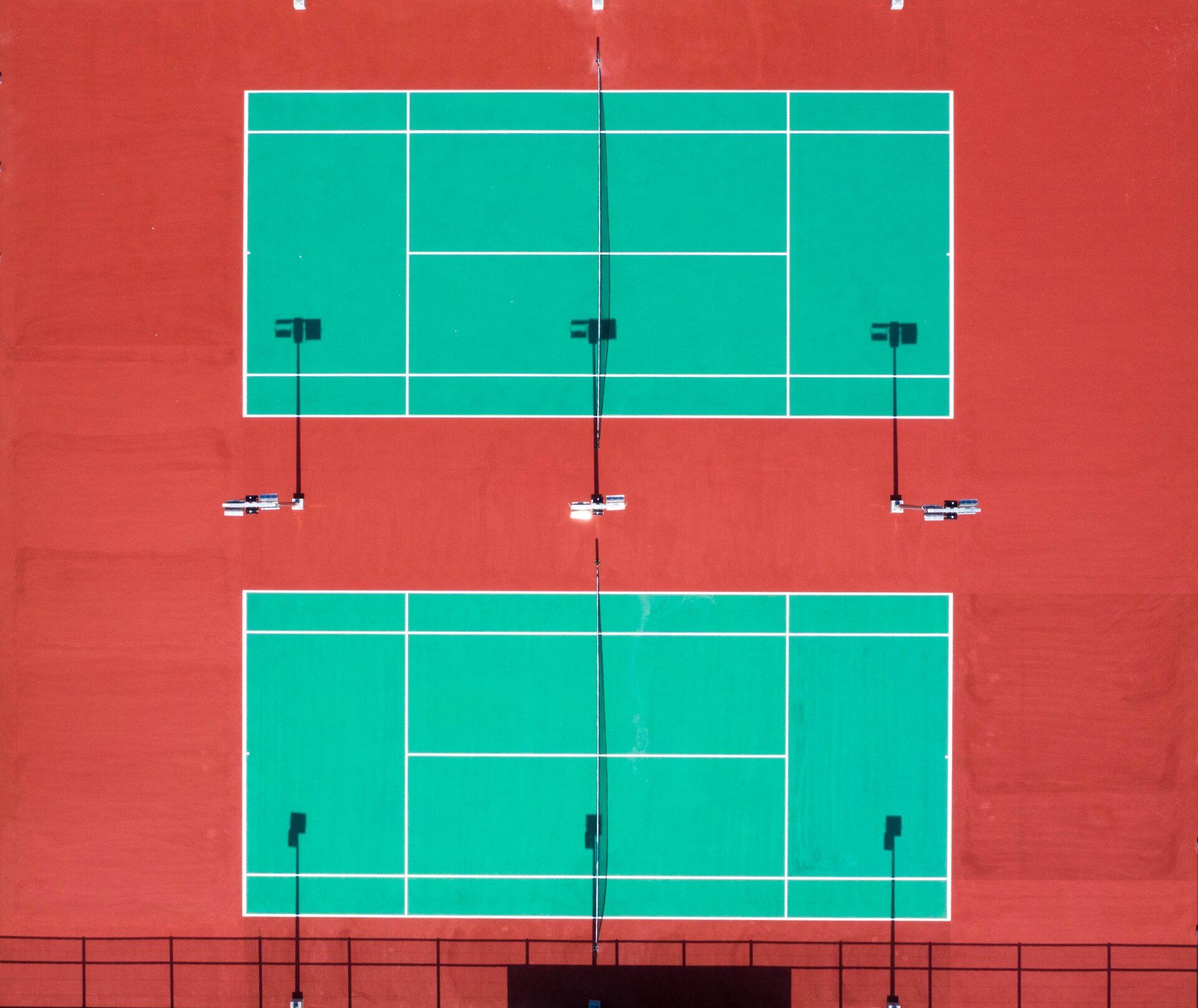 Green tennis courts with white markings.
