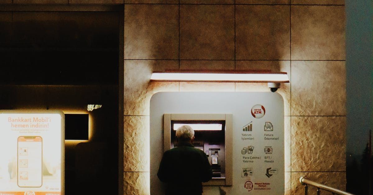 A man standing in front of an ATM machine in a financial banking building