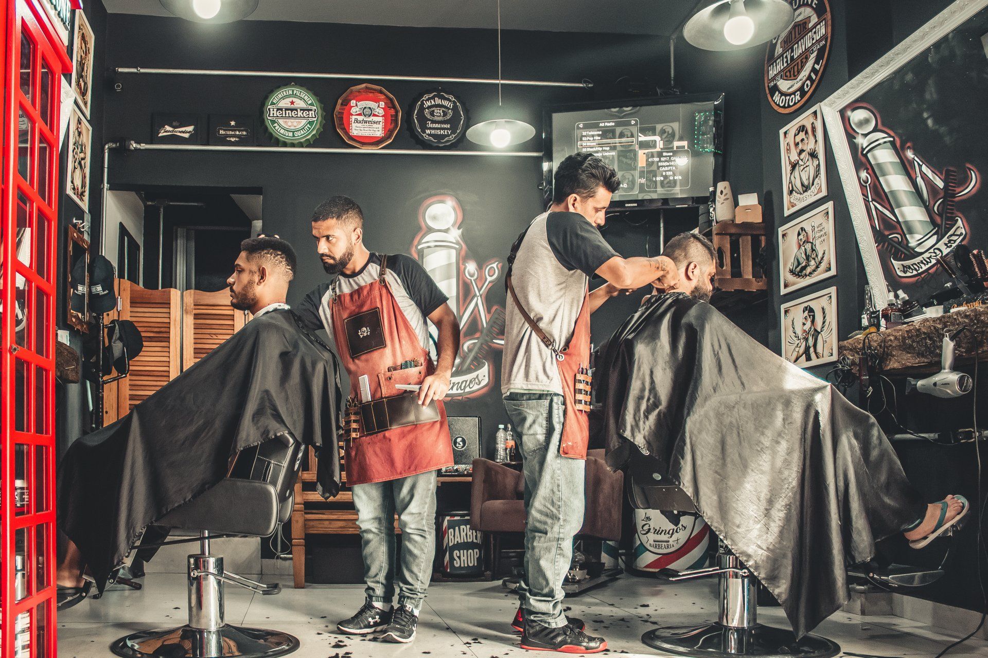 A group of men are getting their hair cut at a barber shop.