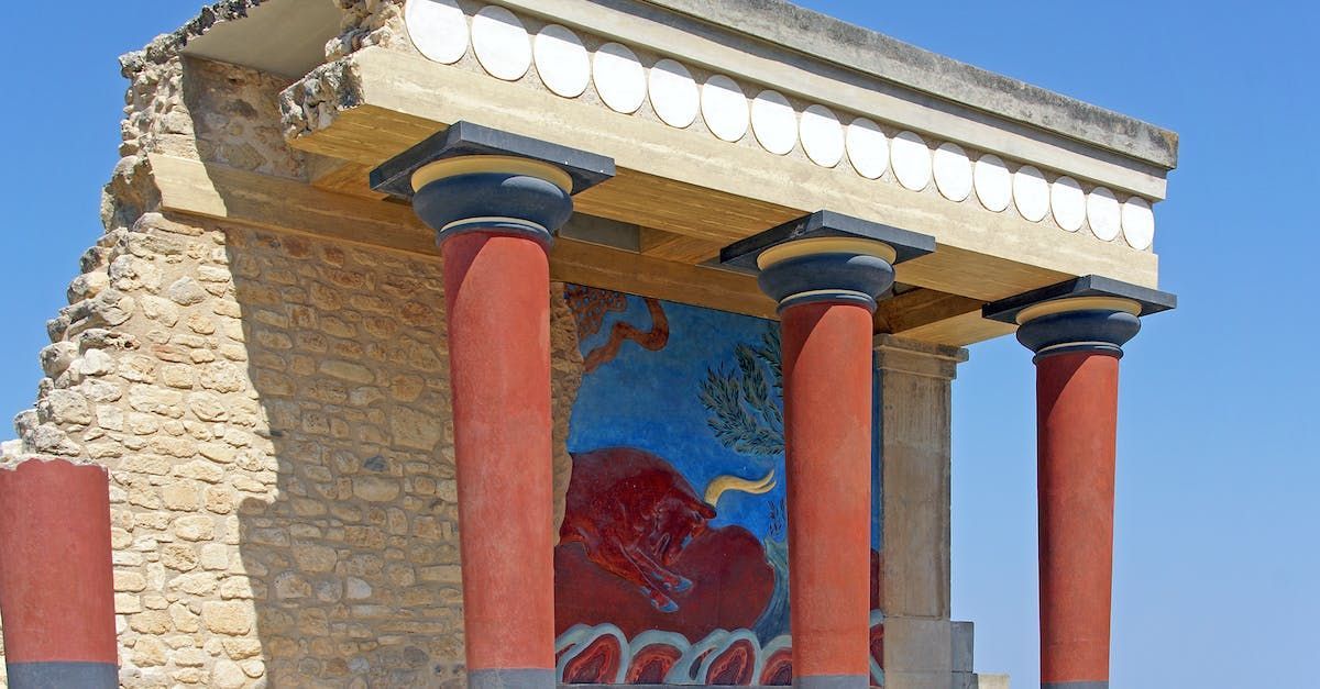 A very old building with columns and a painting on the side.