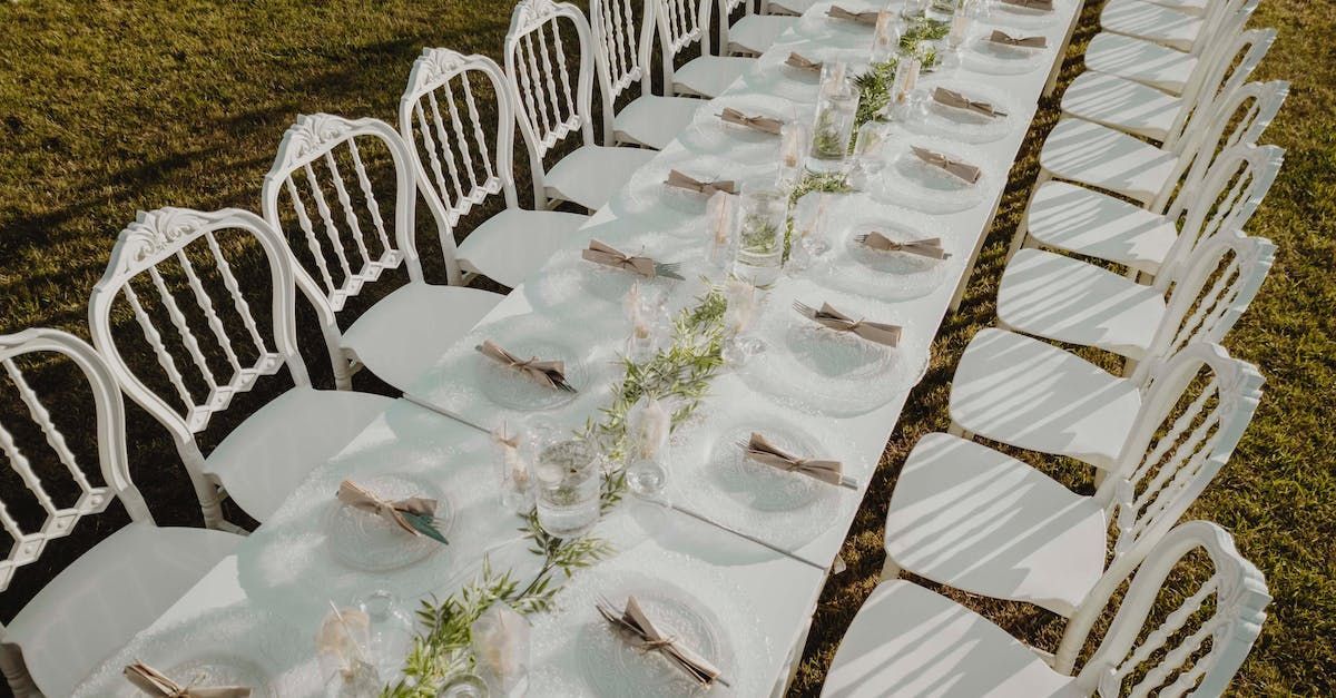 a long table with plates and napkins on it is sitting in the grass .