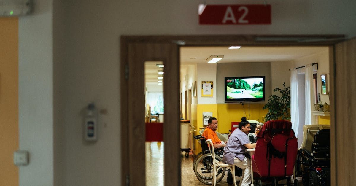 A group of people are sitting at a table in a room with a sign that says a2