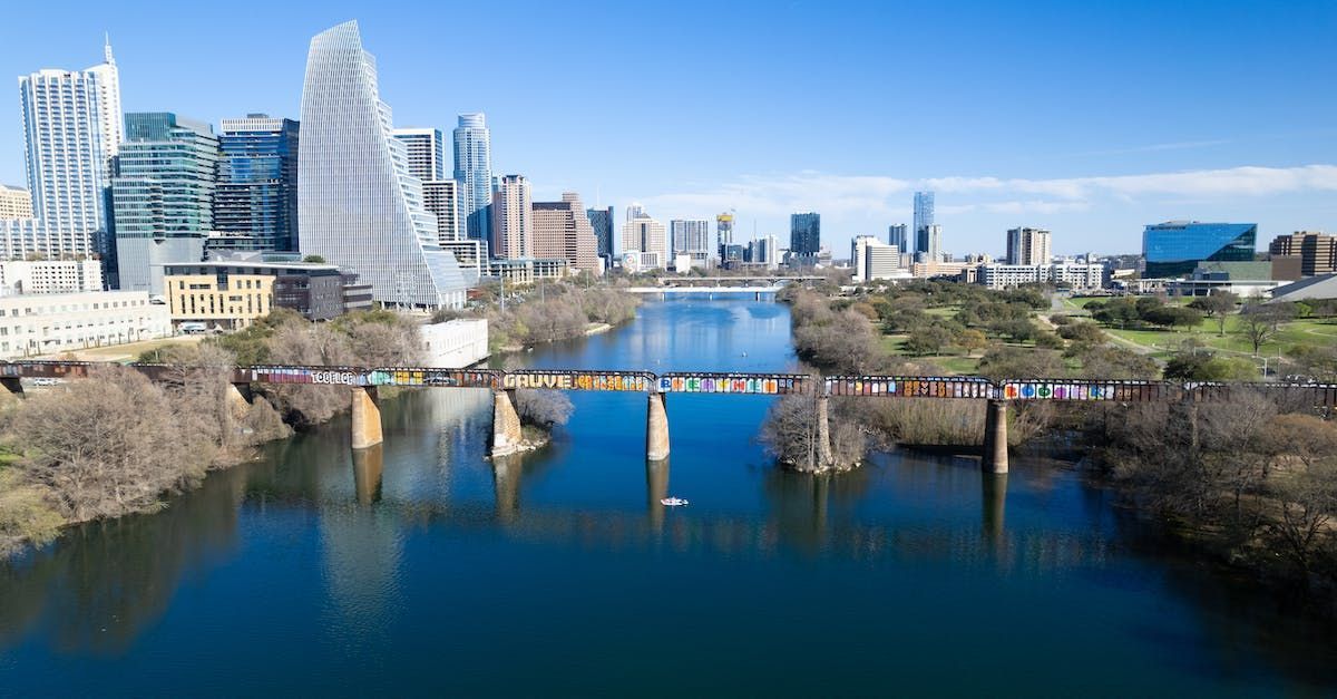 A bridge over a river with the city of Austin skyline in the background.
