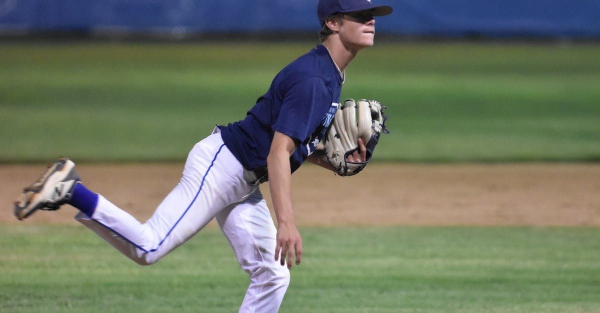 A baseball player is throwing a ball on a field.
