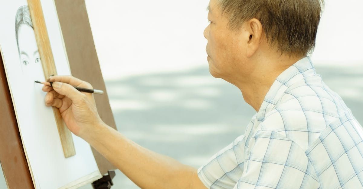 A man is drawing a picture on an easel with a brush.