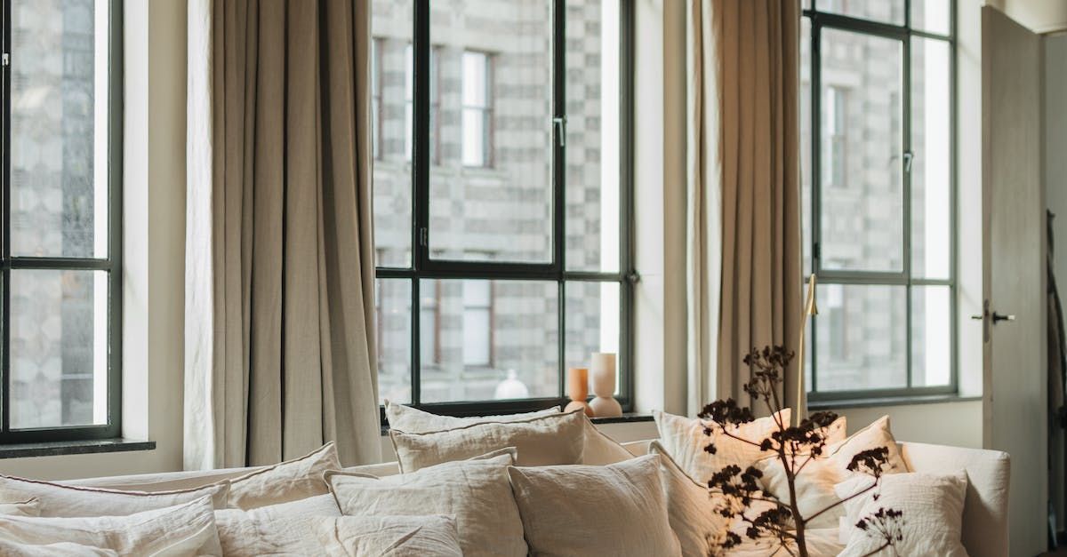 A living room with a couch and lots of windows.