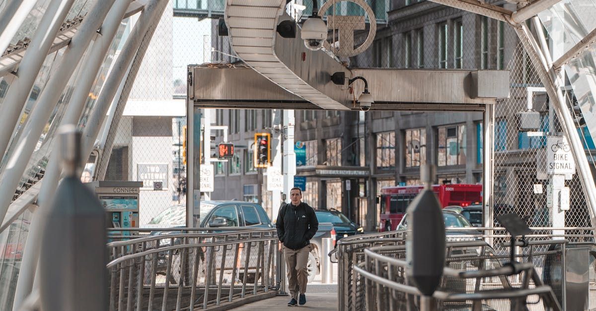 a man is walking across a bridge in a city .