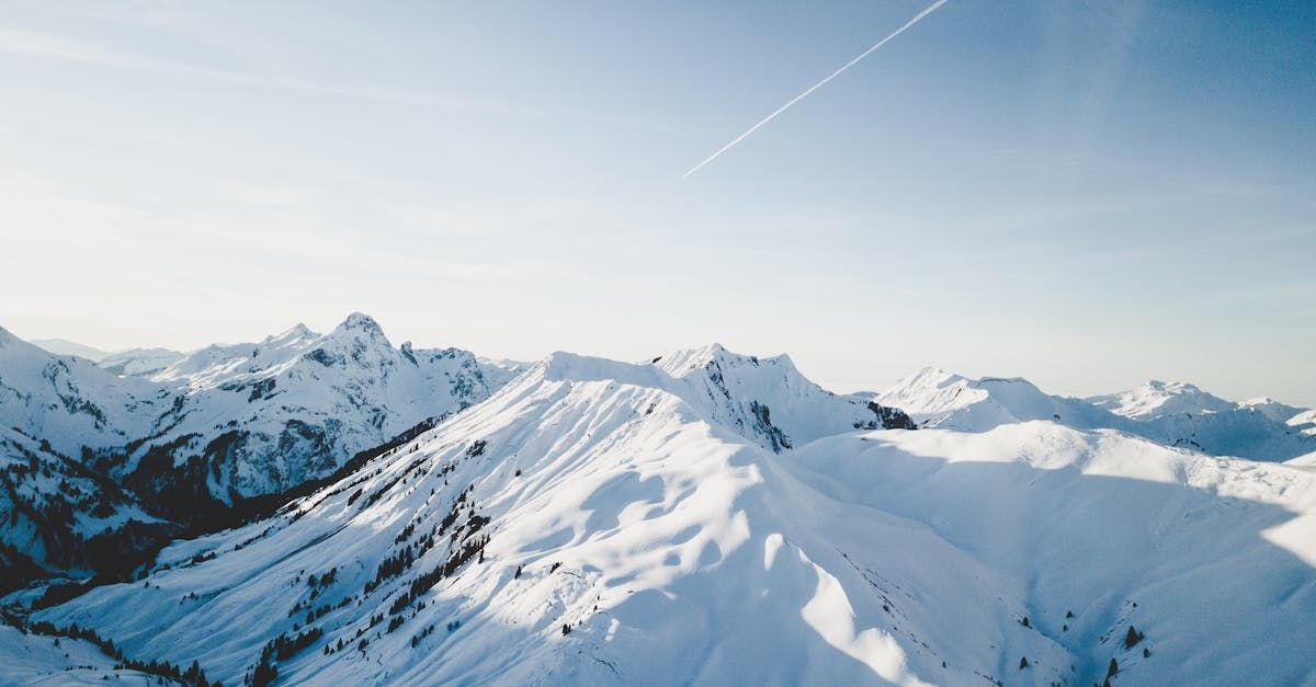 A snowy mountain range with a blue sky in the background