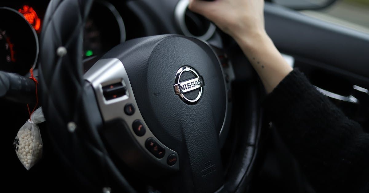 a woman in a blue jacket is driving an audi car