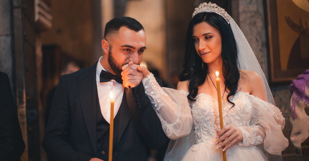 a bride and groom lighting candles in a church