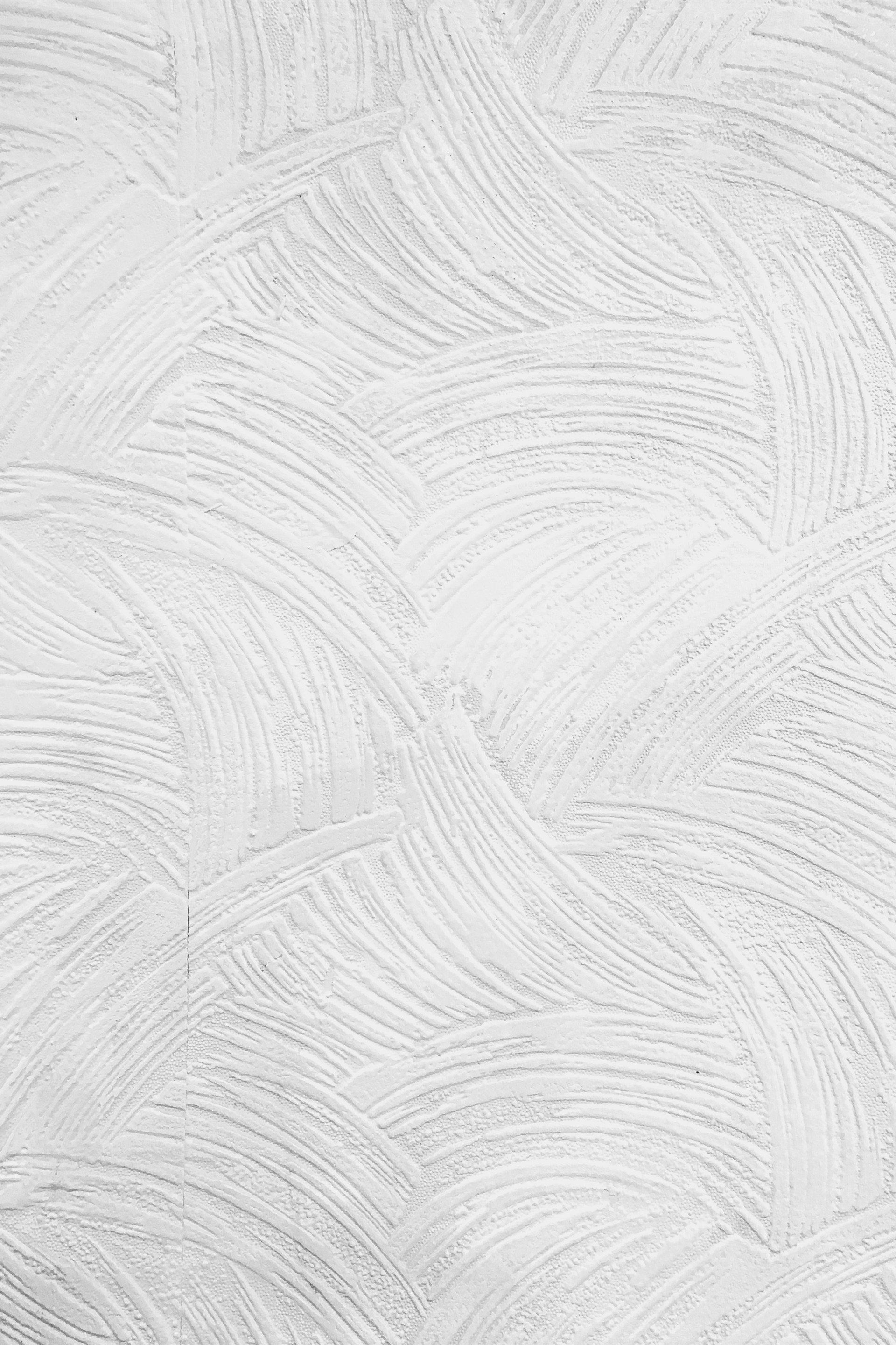 A close up of a white wall with brush strokes.