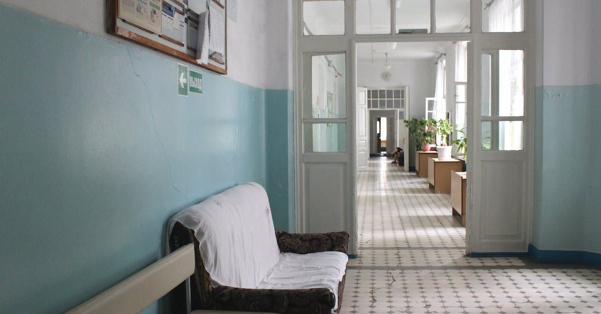 A nurse is cleaning the floor of a hospital with a mop.