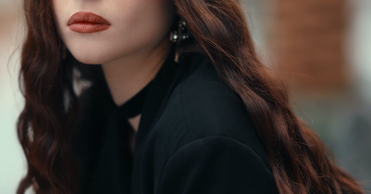 A close up of a woman 's face with long hair and red lips.