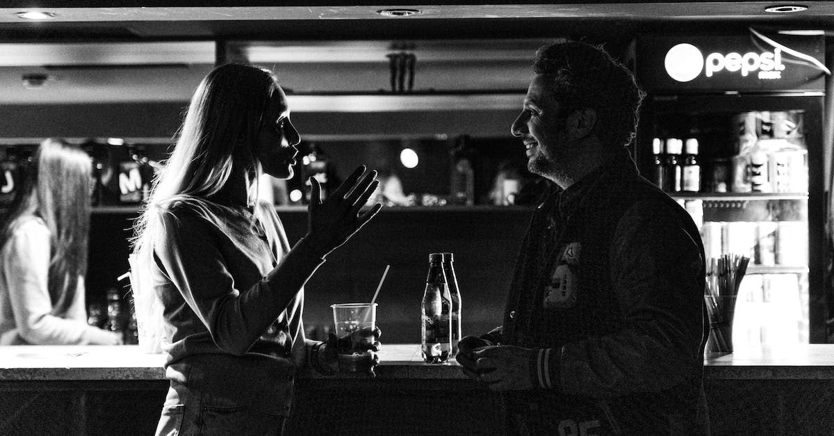 un uomo e una donna parlano in un bar accanto a una pepsi