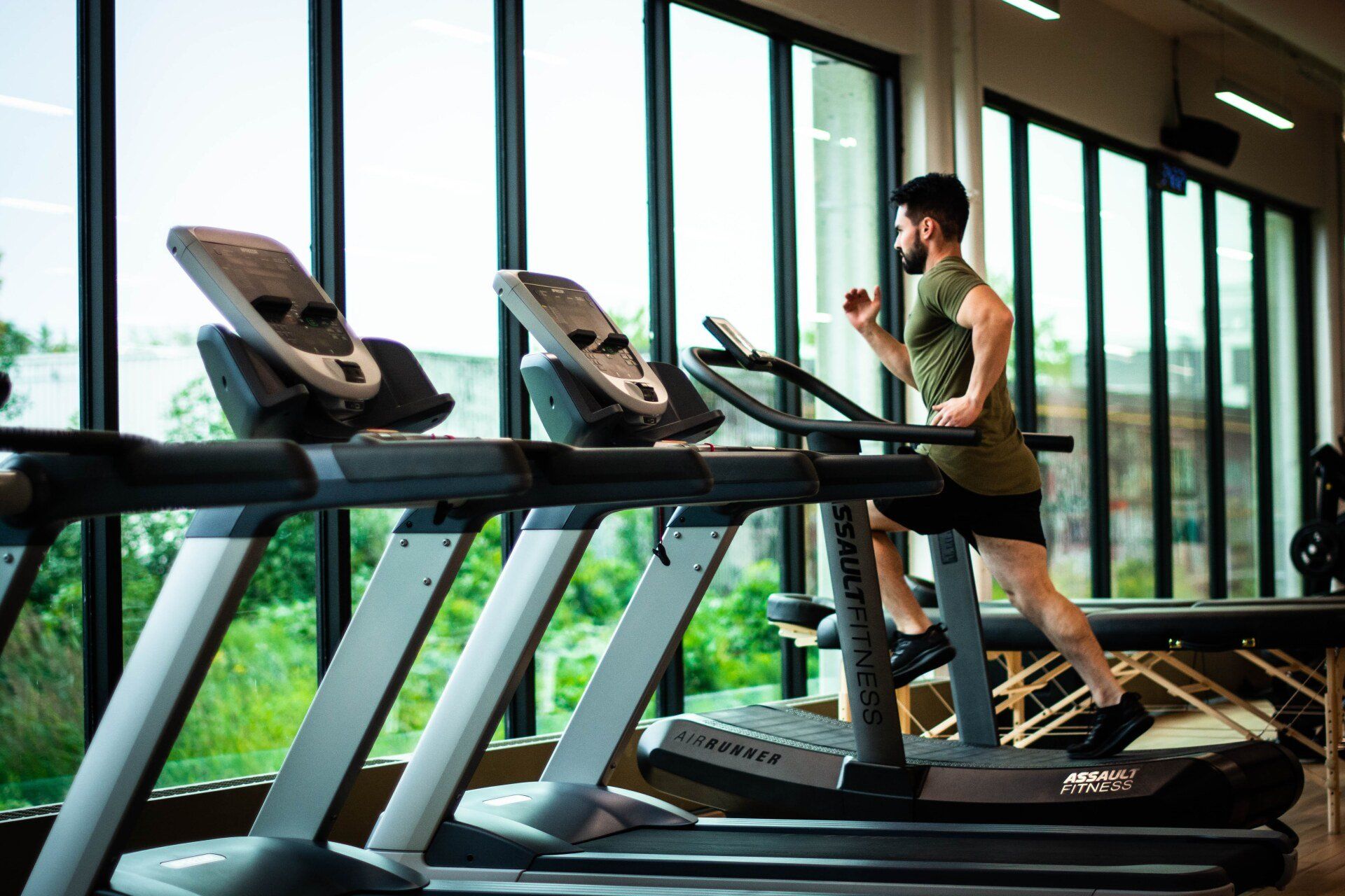 A man is running on a treadmill in a gym.