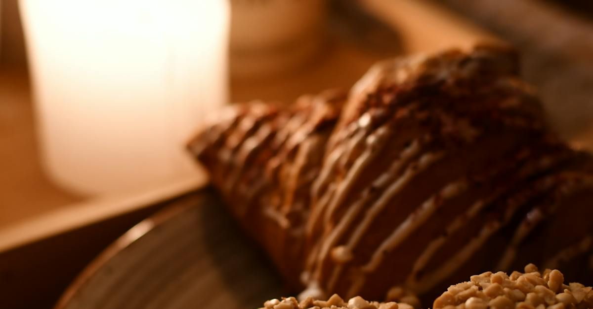 A close up of two pastries on a table with a glass of milk in the background.