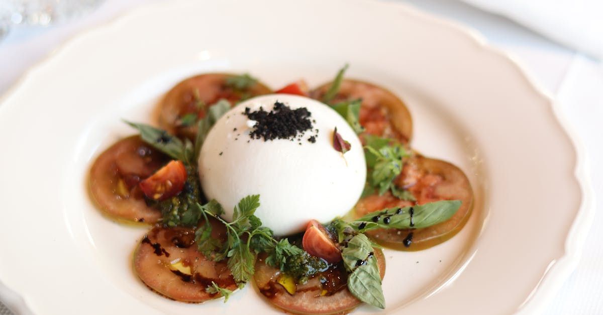 A white plate topped with tomatoes and a white egg